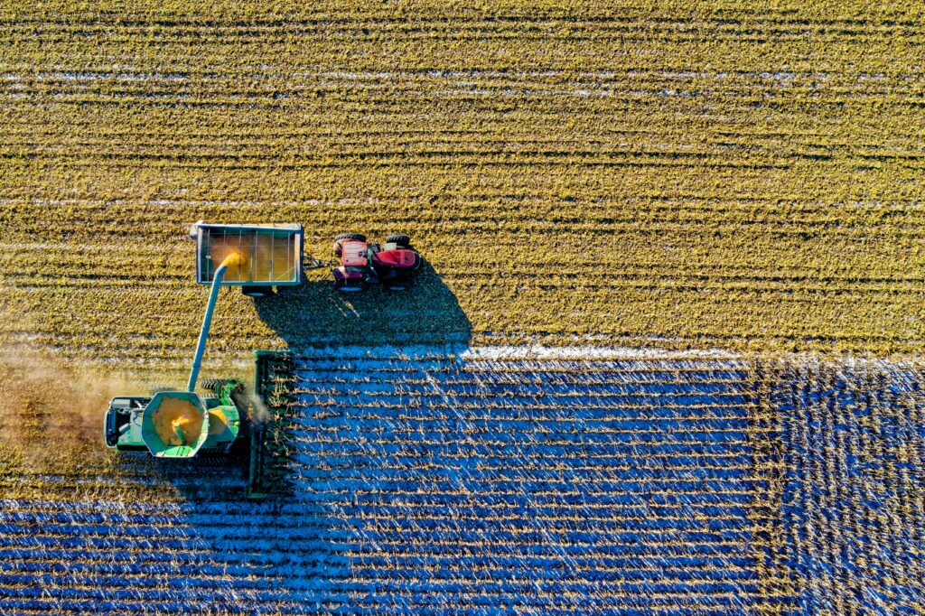 pexels-photo-1595104-1595104 Drone captures vibrant aerial view of tractors harvesting corn in Minnesota field.
